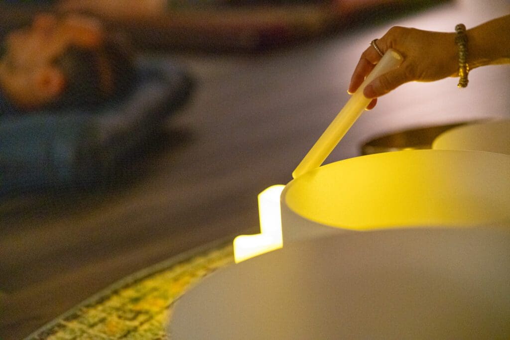 Hand playing a crystal singing bowl.