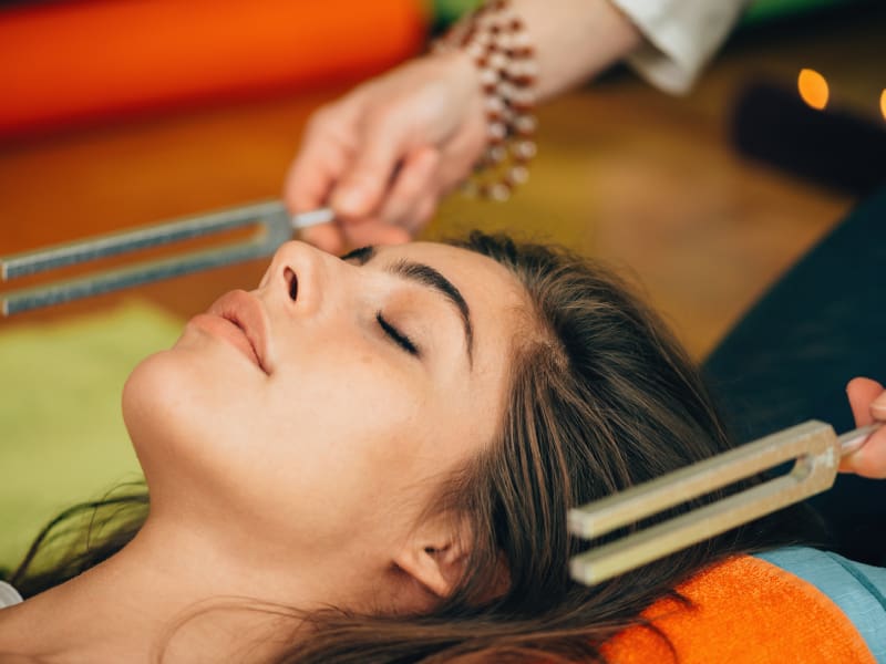 Woman receiving sound therapy treatment.