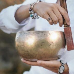 Person striking a singing bowl.