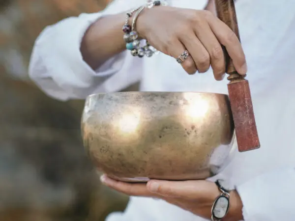 Person striking a singing bowl.