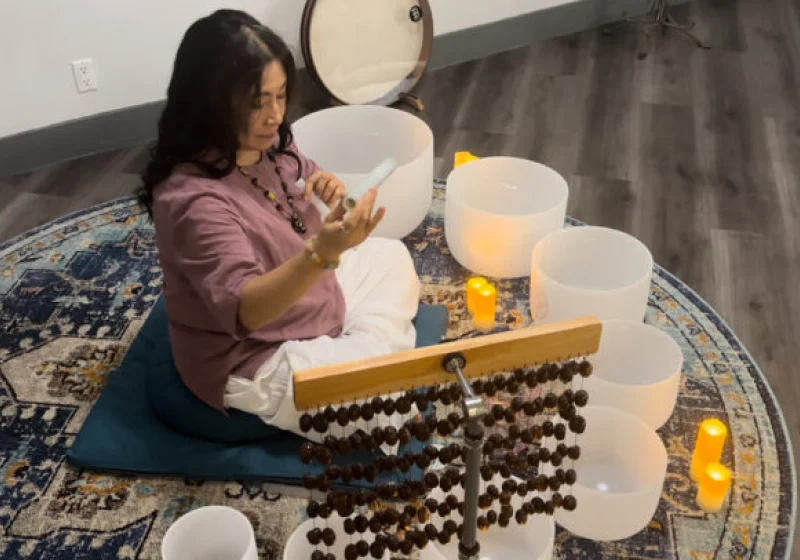 Woman playing crystal singing bowls.